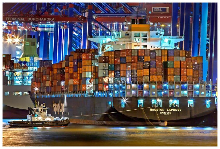 A brightly lit cargo ship at Hamburg harbor with s