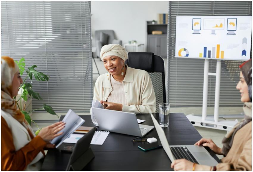 Smiling businesswomen in hijabs at a modern office