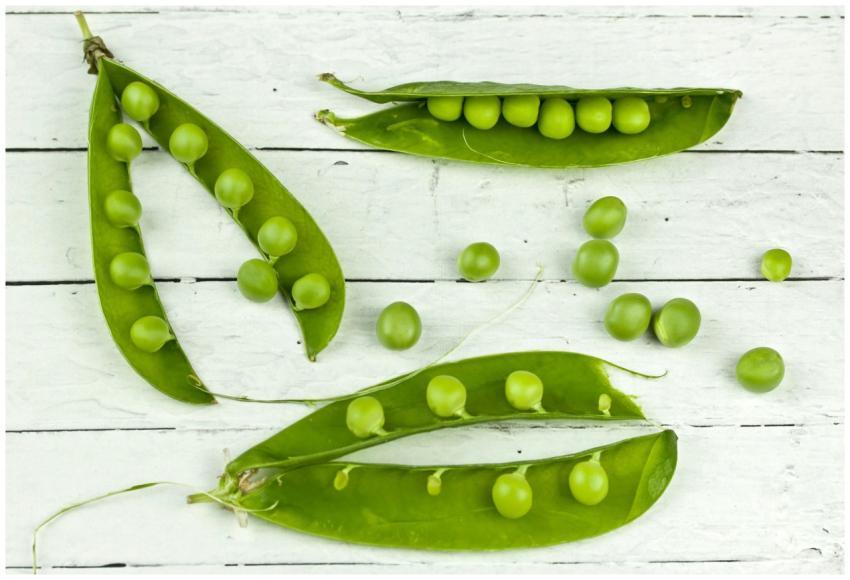 Top view of fresh green peas and pods on a rustic