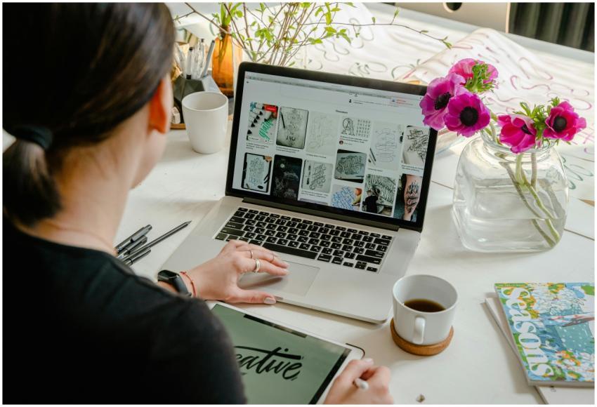 Woman in a creative workspace using a laptop and t