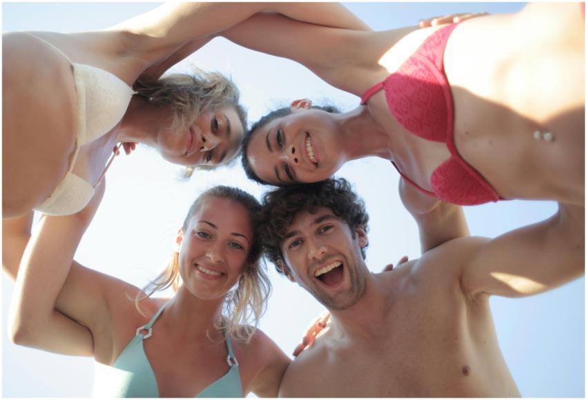 Lively group of friends smiling in swimsuits again