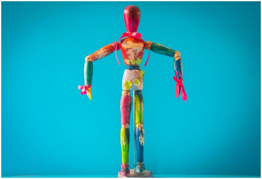 A vibrant wooden mannequin painted in various colo