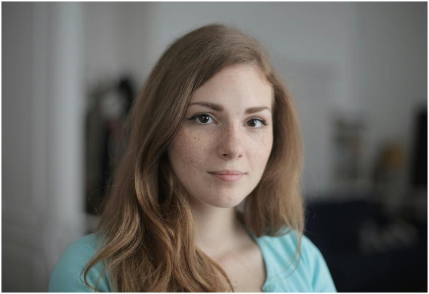 Close-up portrait of a young freckled woman indoor