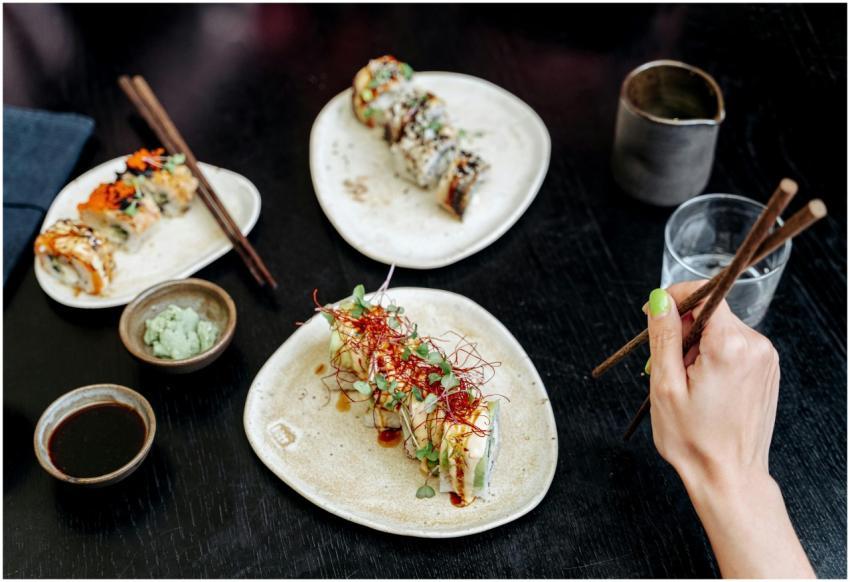 Close-up of assorted sushi rolls with chopsticks a