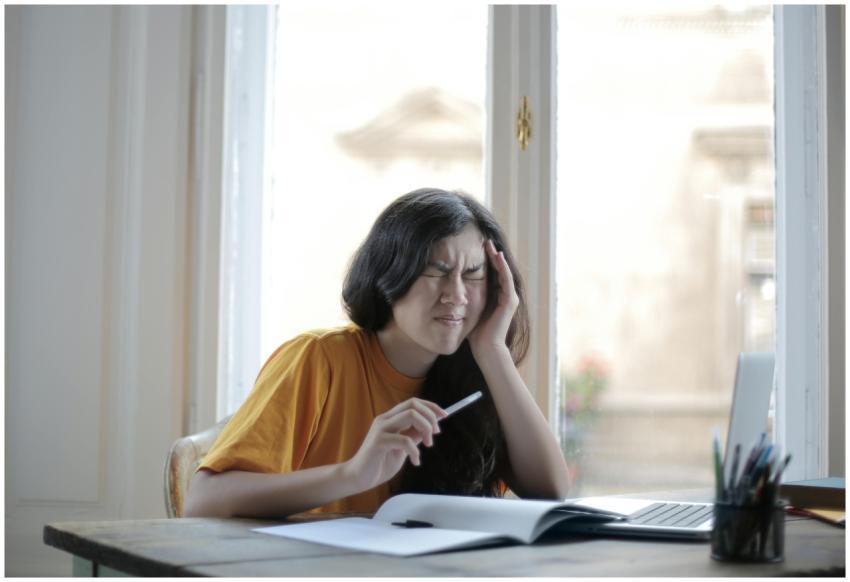 Ethnic female student in casual wear sitting at ta