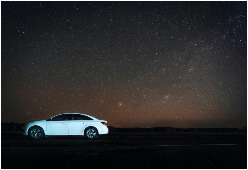 White car parked under a stunning starry sky in So
