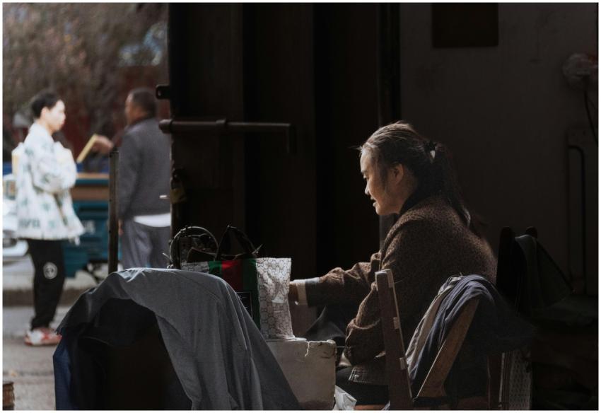 A focused woman operates a sewing machine in a sha