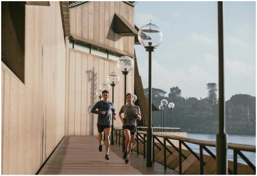 Two people jogging by the Sydney Opera House on a
