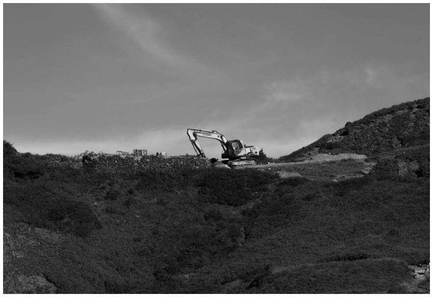 Black and white photo of an excavator on a mountai