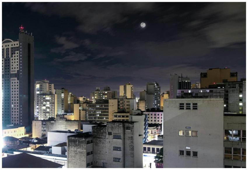 Vibrant city nightscape with a full moon and illum