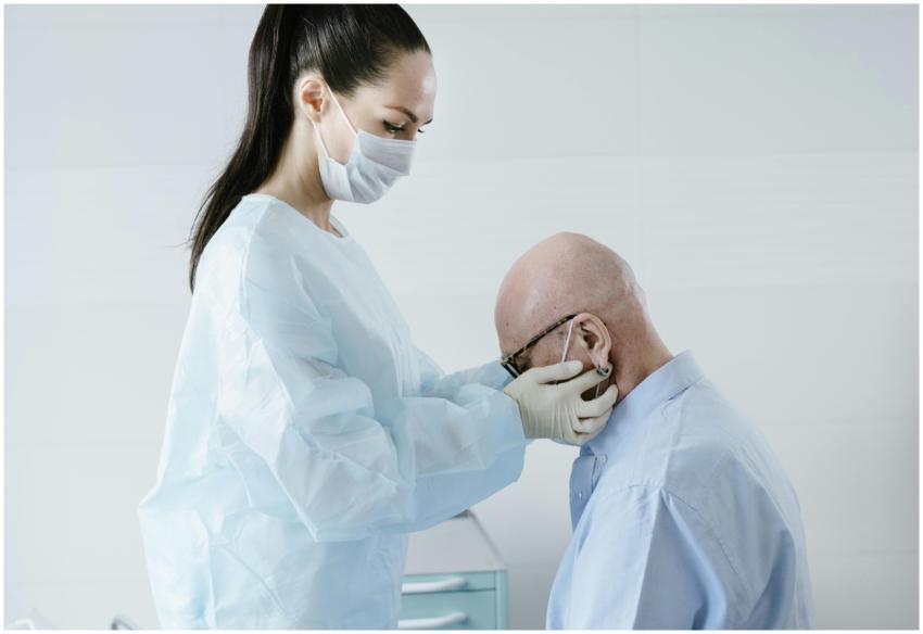 Masked doctor examines elderly patient in clinical