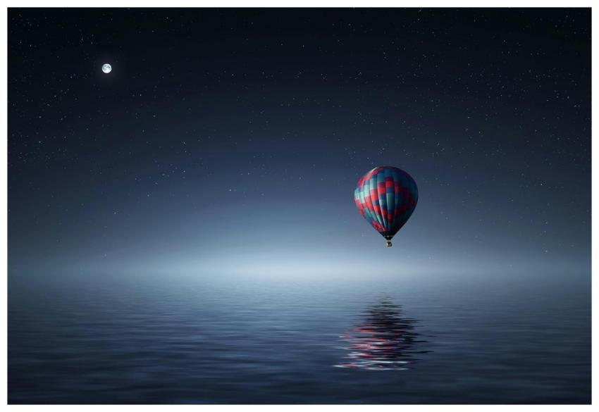 A serene hot air balloon floating over the ocean u