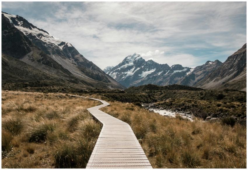 Wooden walkway leads through rugged landscape towa