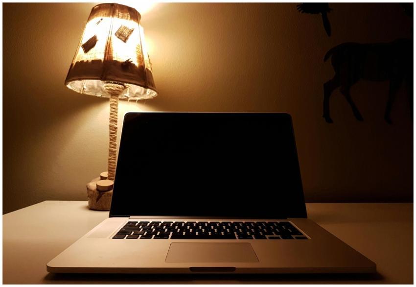 Warm light from a table lamp illuminating a laptop