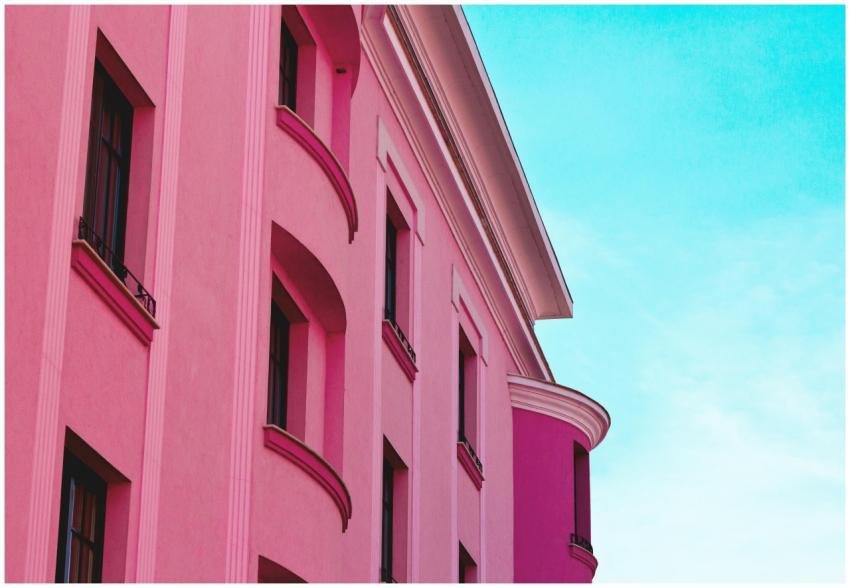 A stunning pink building facade against a bright b
