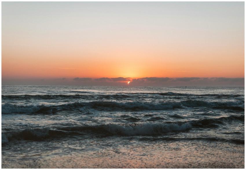 A tranquil sunset over the ocean with gentle waves