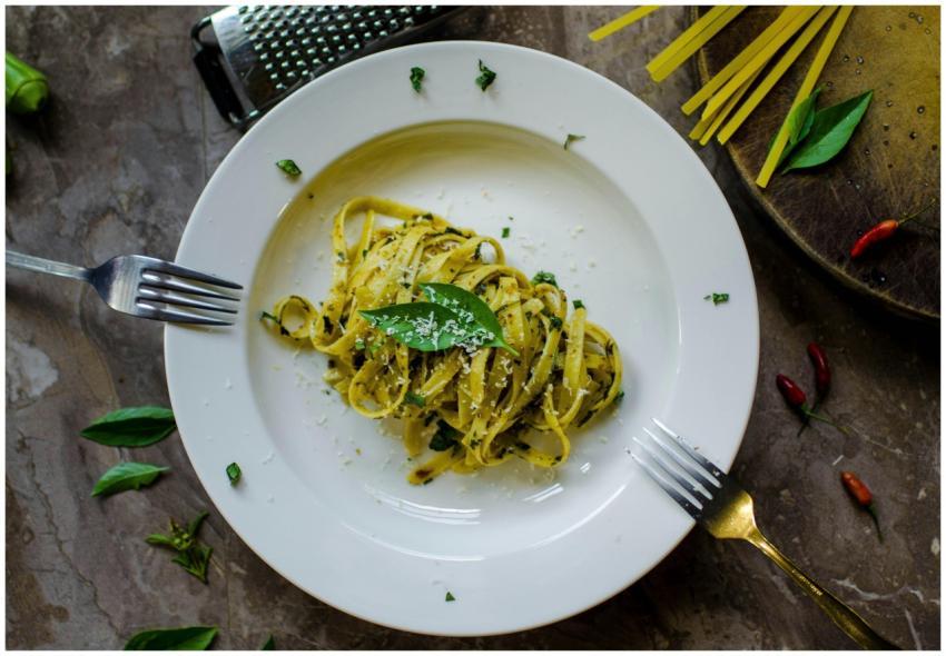 A tempting plate of basil pesto pasta garnished wi