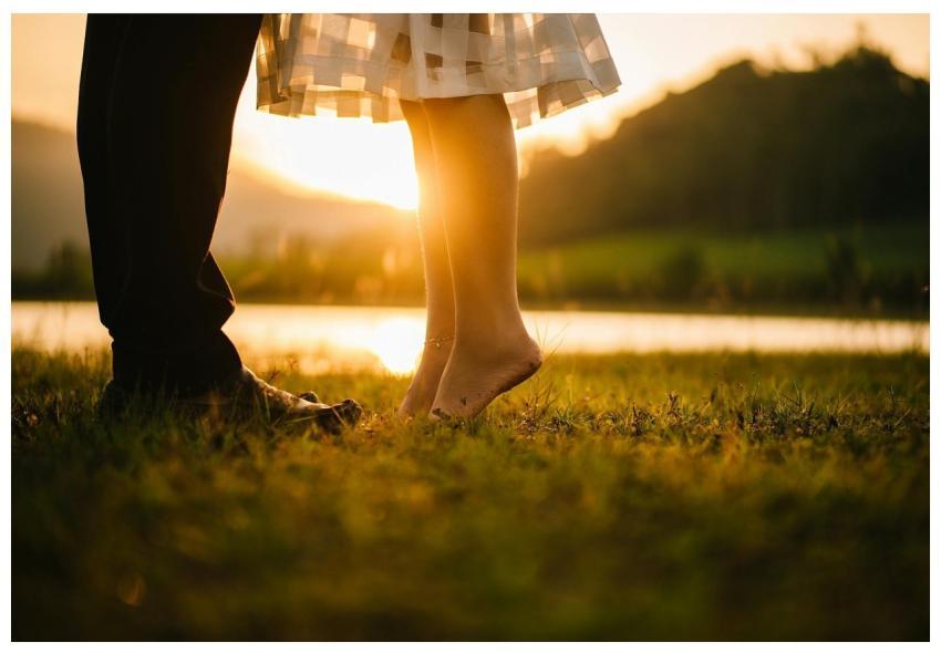 A romantic moment captured at sunset by a tranquil