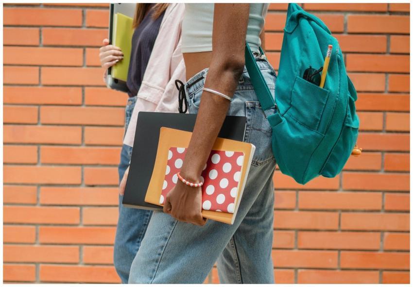 Two students walking side by side with backpacks a