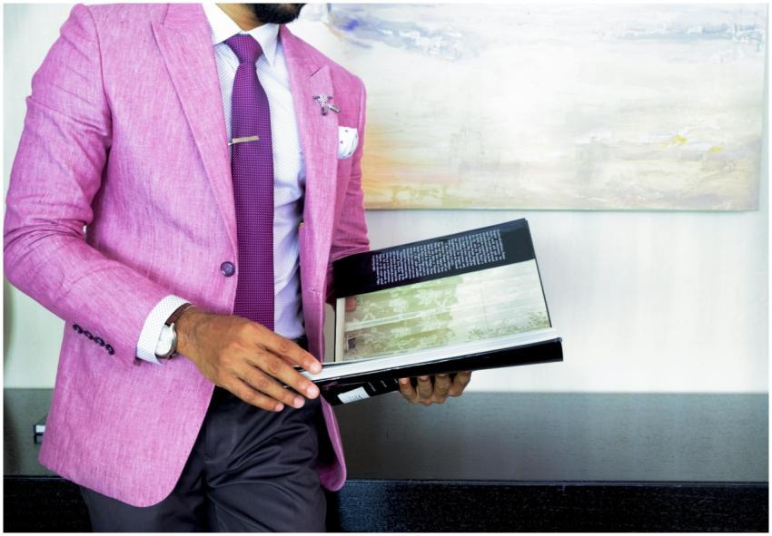 A businessman in a pink suit holding a book, symbo