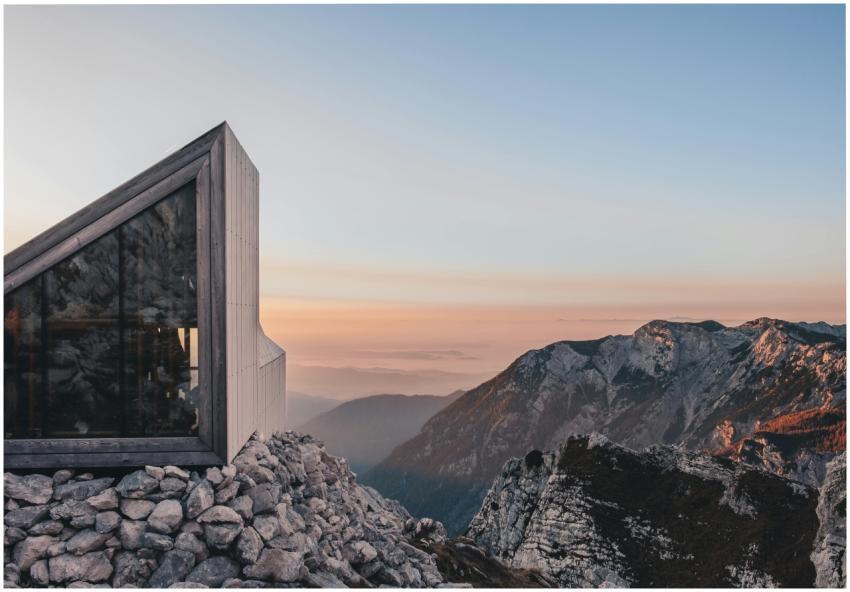 A sleek modern cabin perched on rocky terrains in