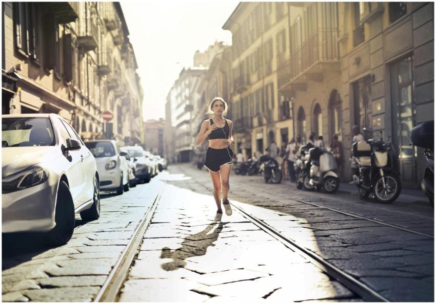 Energetic woman jogger running down a city street