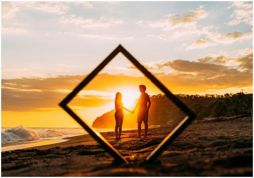 Couple holding hands at sunset on a beach in El Sa