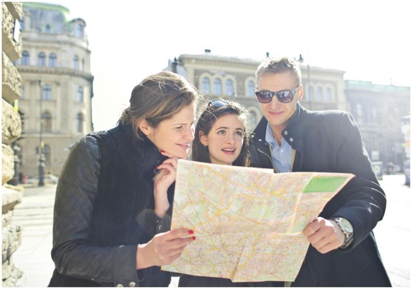 Three tourists exploring a city using a map under