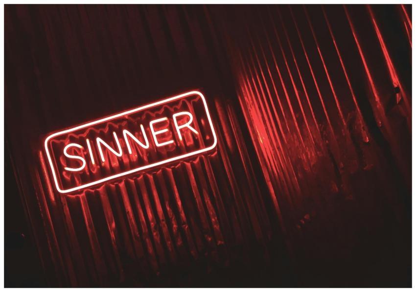 Bright red neon sign displaying the word 'SINNER'