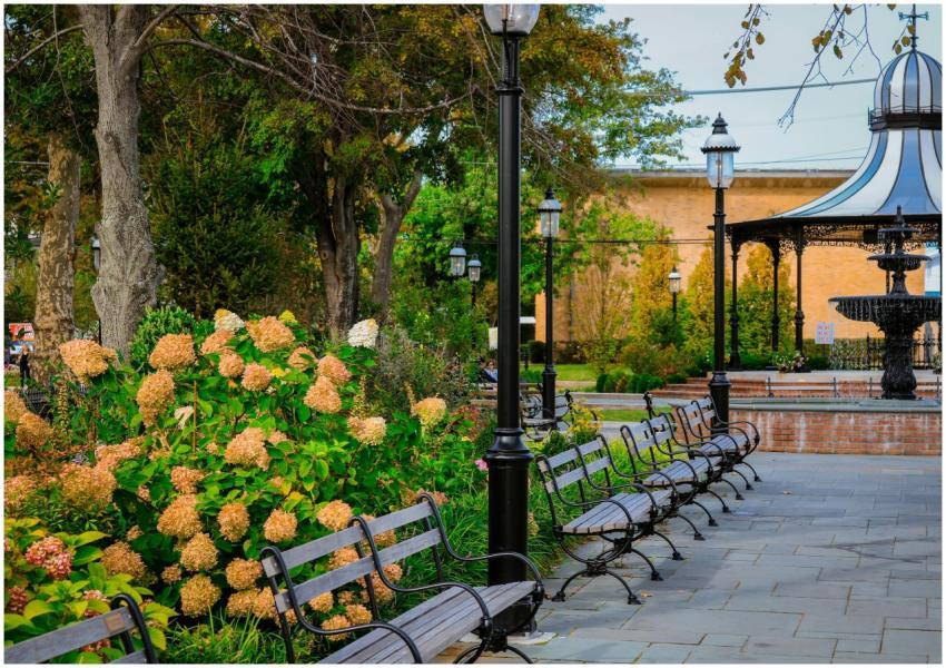 A peaceful park setting with a gazebo, flowers, an