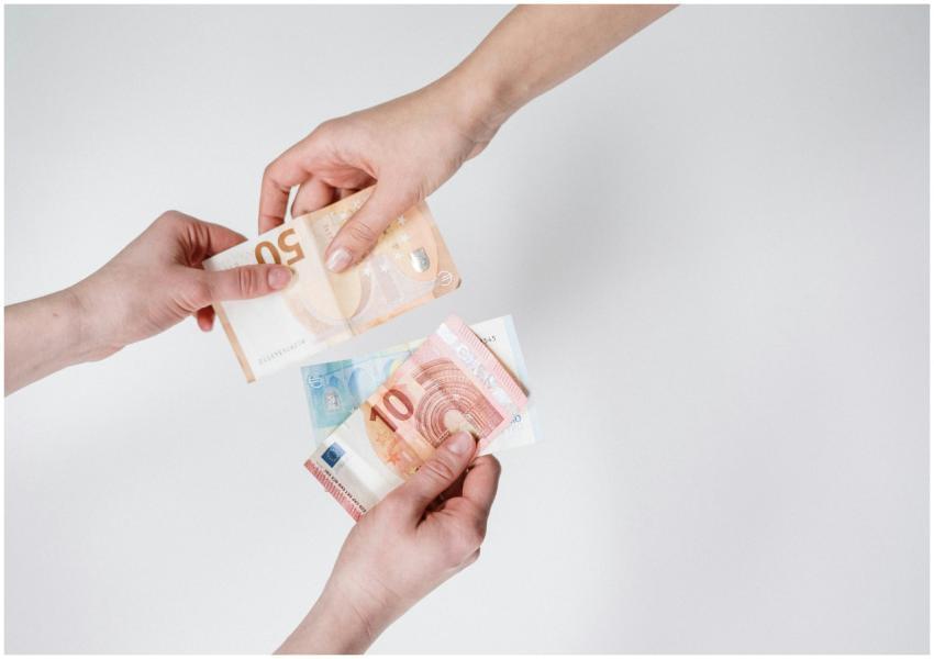 Close-up of hands exchanging euro bills, symbolizi