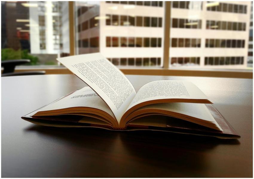 An open book sits on a desk in an office overlooki