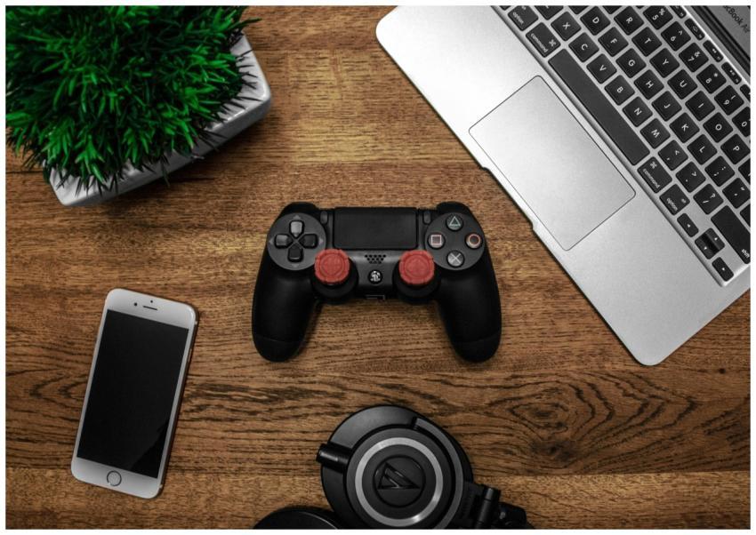 A flat lay photo showcasing a gaming console, lapt