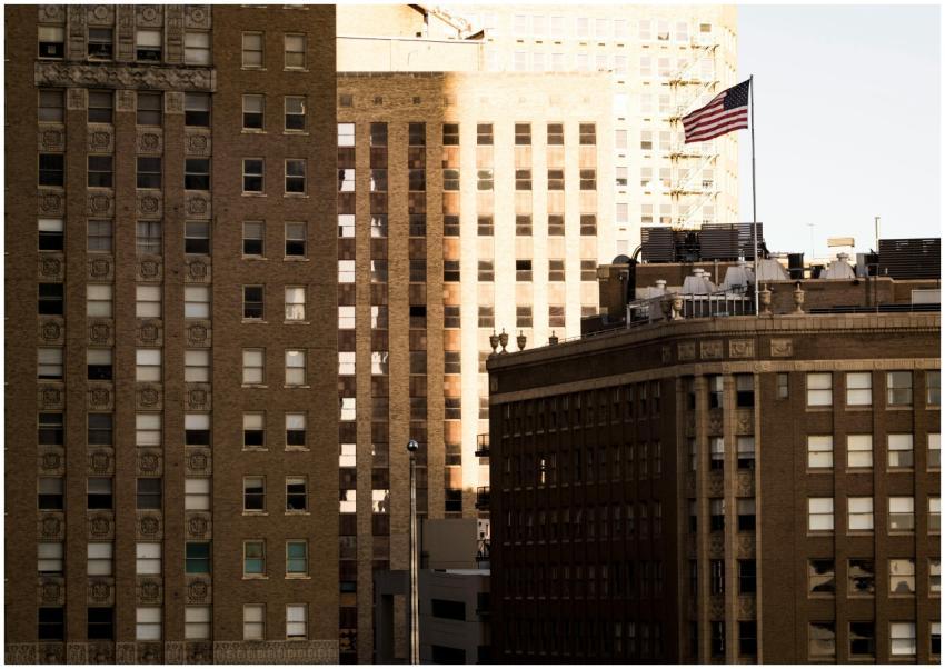 A cityscape view with brown buildings and an Ameri