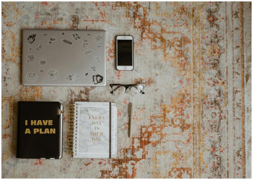 Flat lay of workspace items including laptop, phon