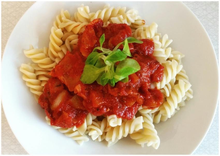 Spirelli pasta topped with rich tomato sauce and f
