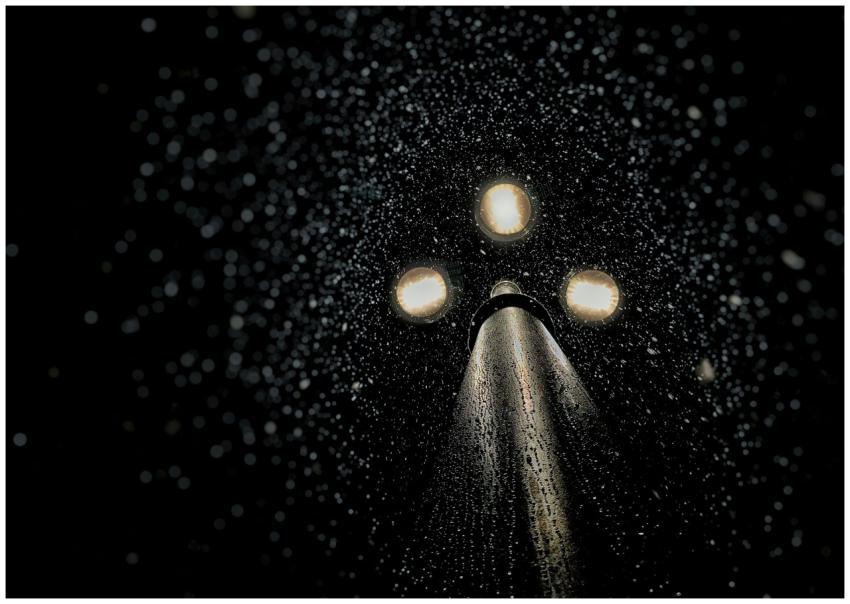 Artistic capture of rain-drenched street lamp illu