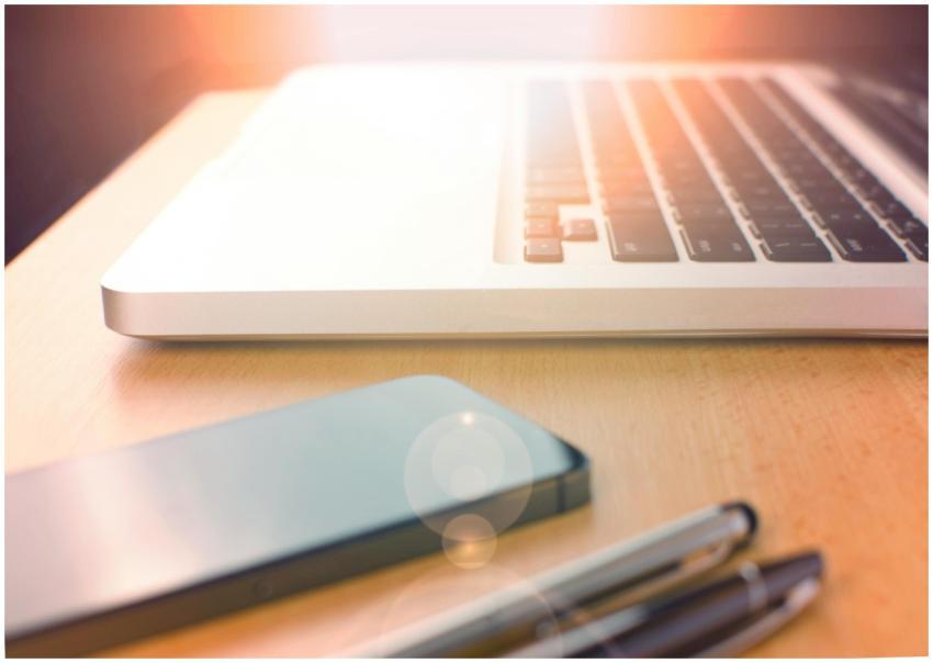 Stylish desk setup featuring a laptop, smartphone,