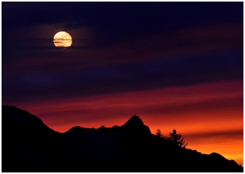 A captivating scene of a full moon above silhouett