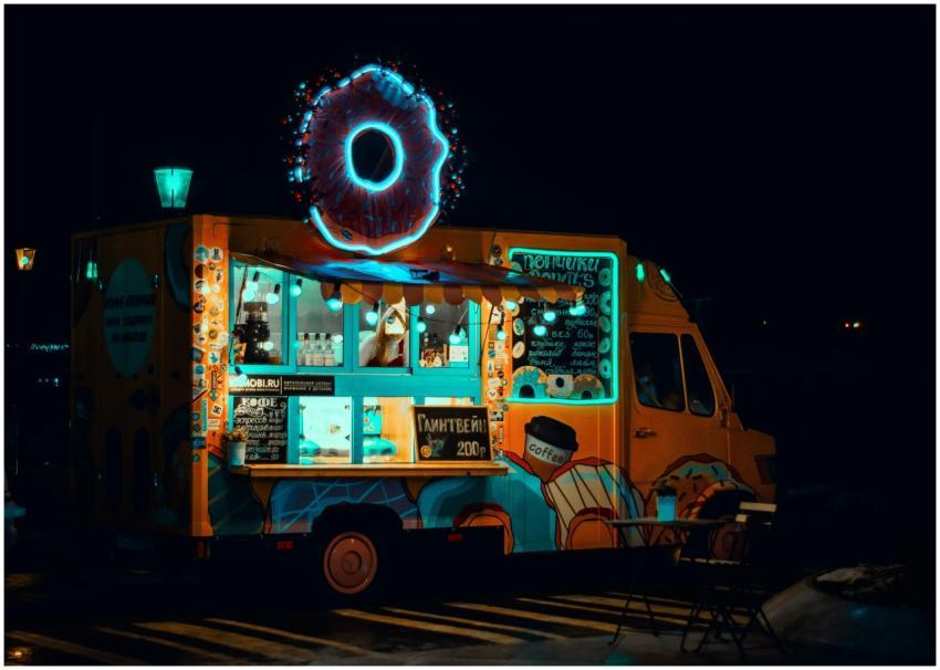 Vibrant neon food truck at night serving snacks wi