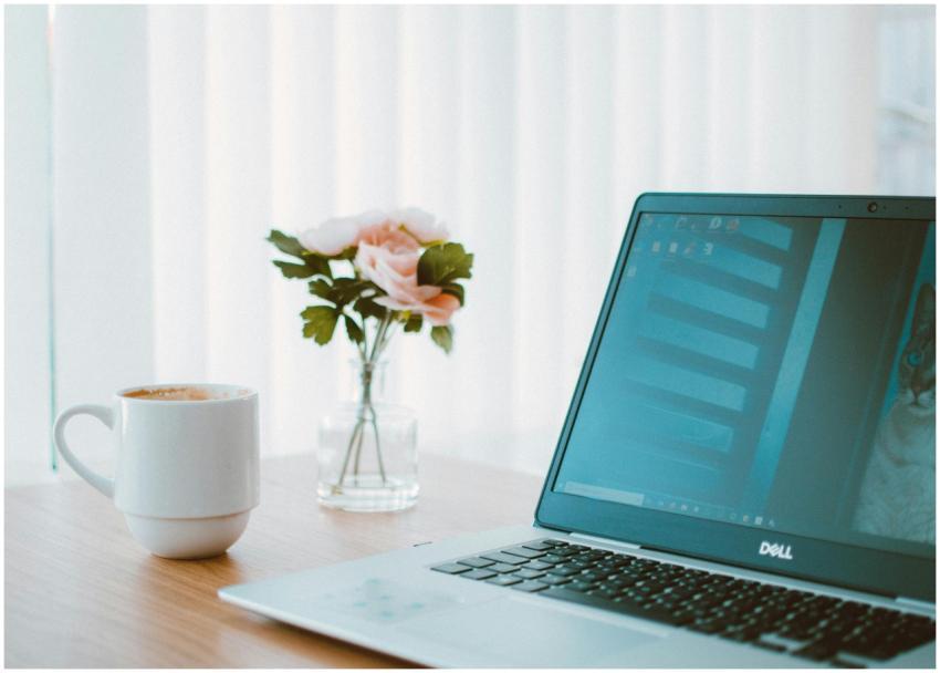 Comfortable home office desk with laptop, coffee m