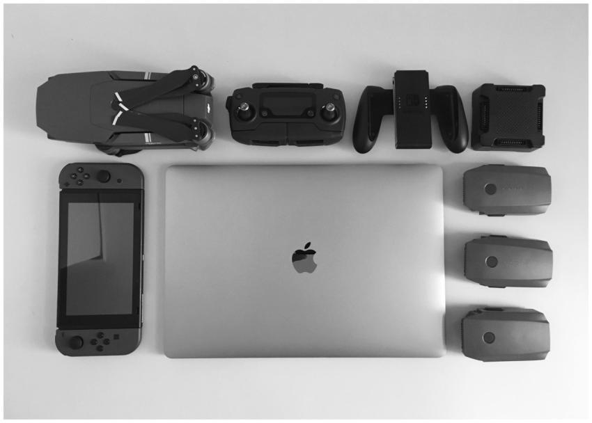 A black and white flat lay of various modern tech