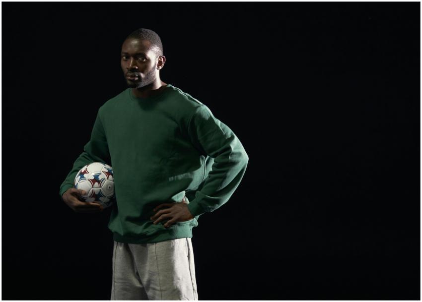 Studio portrait of a man in a green sweatshirt hol