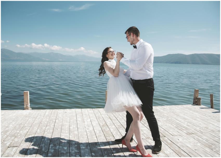 A couple joyfully dances on a dock by Lake Oteshev