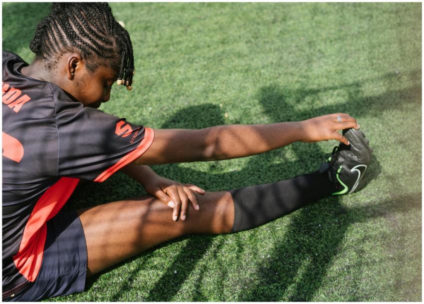 From above of black female soccer player sitting o