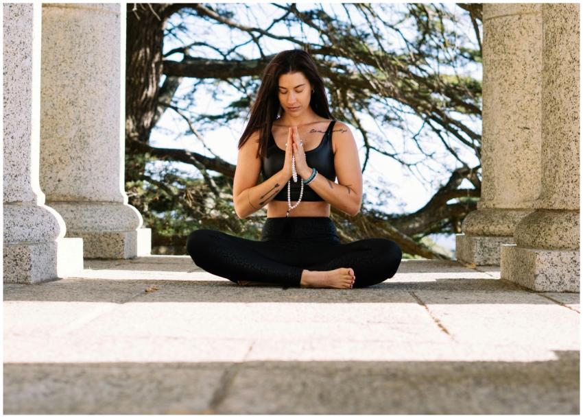 Woman practicing meditation in nature amidst stone