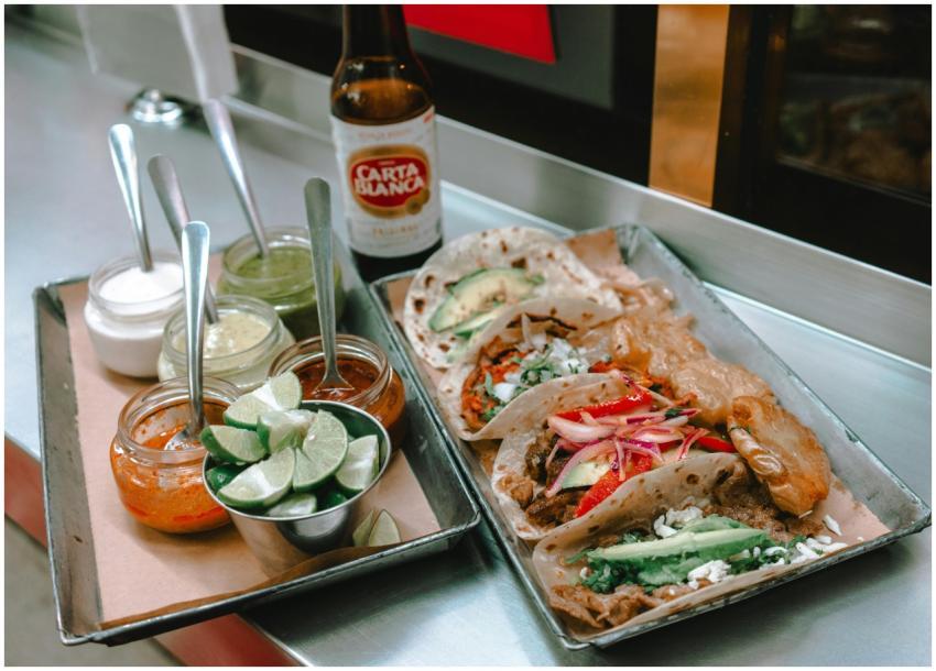 Delicious Mexican tacos served with sauces and lim