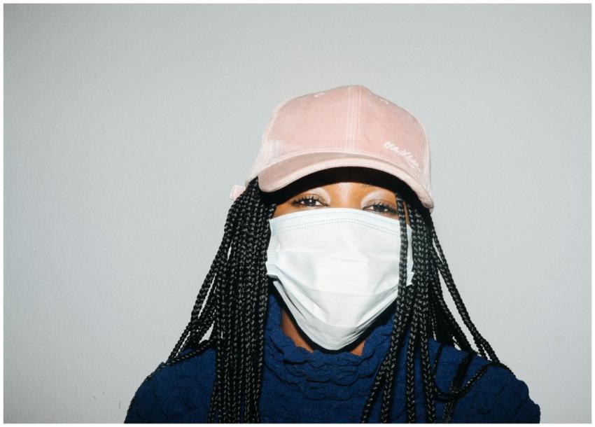 Portrait of a young woman wearing a mask and cap i