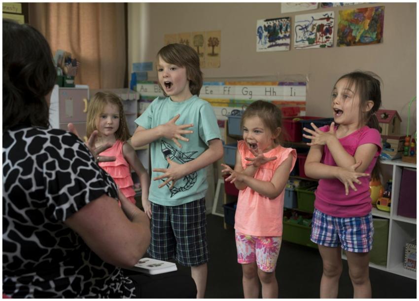 Children learning sign language with a teacher in