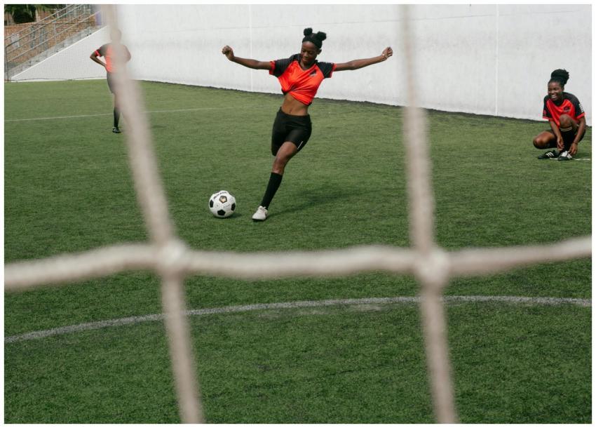 Women soccer players practicing on a green field,